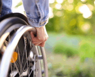 Picture of a hand on the rim of a wheelchair